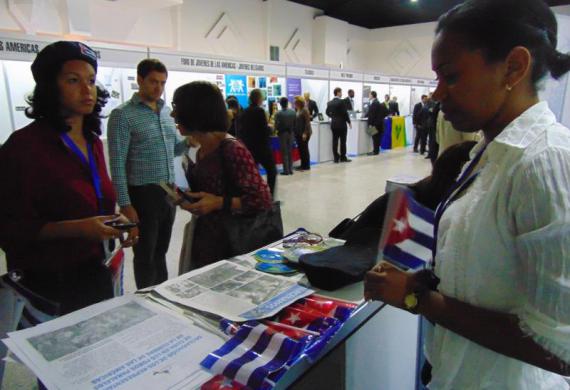 Delegados cubanos atendien a los visitantes de otros países
